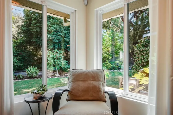 Sitting area next to primary bathroom with corner windows to the backyard.