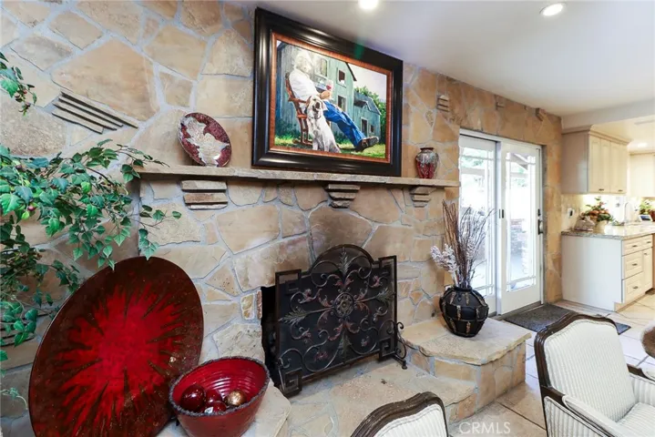 Family Room features Stone gas fireplace with stone wall.  Slider to pool and patio