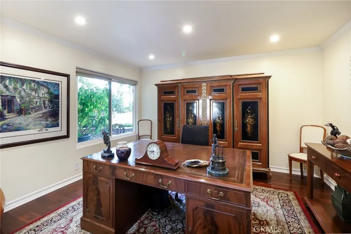 Den used as office. Lovely view of the park like landscape of front yard. Wood floors. Recessed lighting. Crown molding.