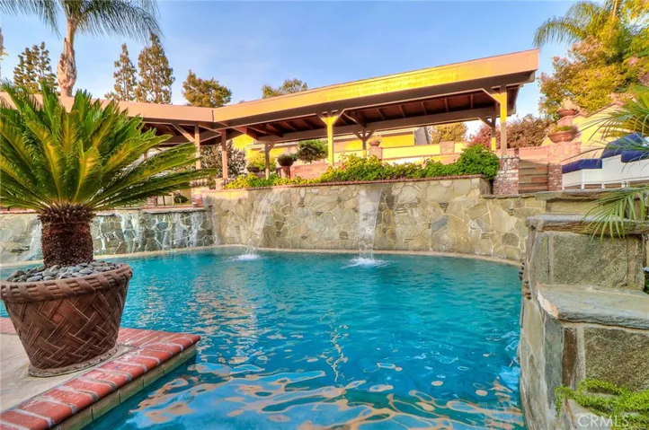 Resort like living with this incredible pool, water falls,  stone work, custom painted wall, 2 huge covered custom patios.