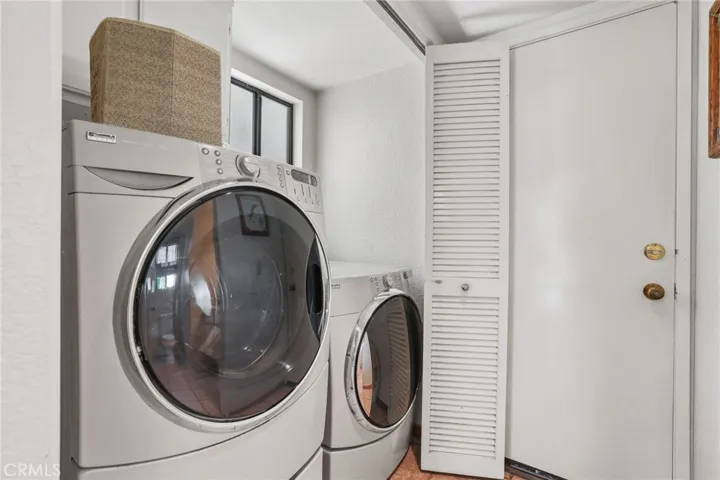 The laundry closet with washer and dryer. The door is to the attached two car garage.