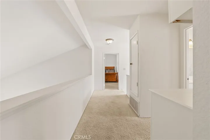 The primary suite is on the opposite side of the hallway, away from the two secondary bedrooms. The second full bathroom is half way to the right.
