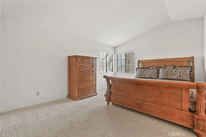 The primary suite is bright and spacious with a high ceiling.