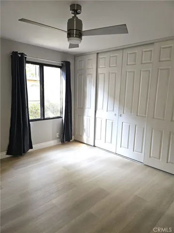 Bedroom #2, with ceiling fan, blackout curtains and an entire wall of storage space!
