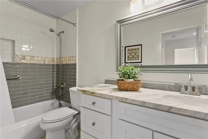 Main floor bathroom with tub shower combination and a handheld shower fixture.