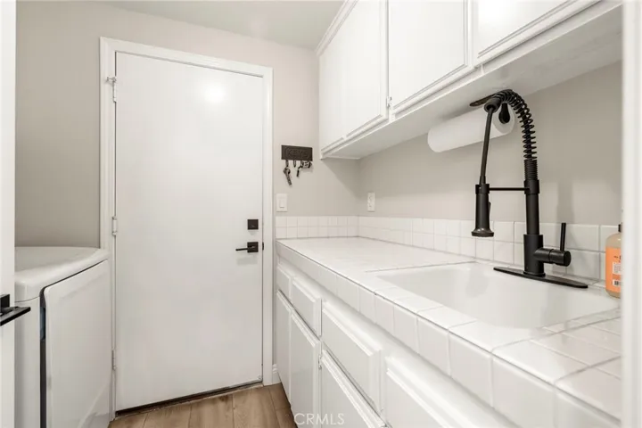 Indoor Laundry room with sink and storage.