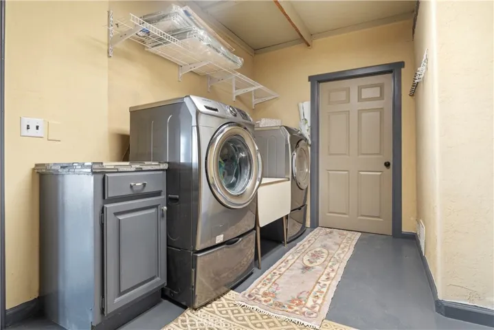 The laundry room includes washer/dryer, task sink and lots of storage