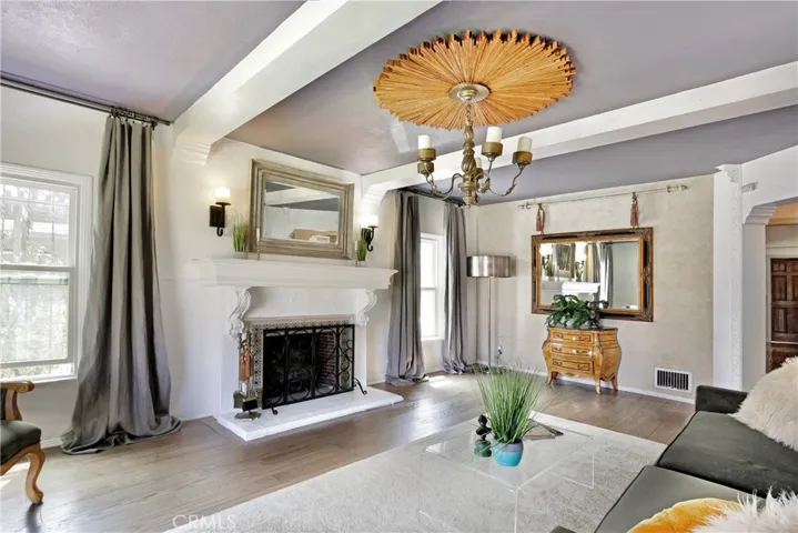 spanish tile framed fireplace, beamed ceiling, scalloped doorway frame