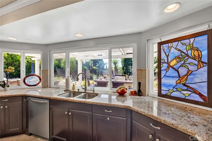 Granite Countertops, Travertine Backsplash, Wall of Garden-View Windows
