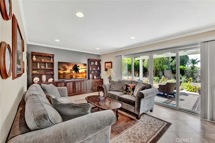 Family Room Boasts Crown Molding, Recessed Lighting, Tile Flooring, and Wall of Glass Overlooking Gorgeous Backyard