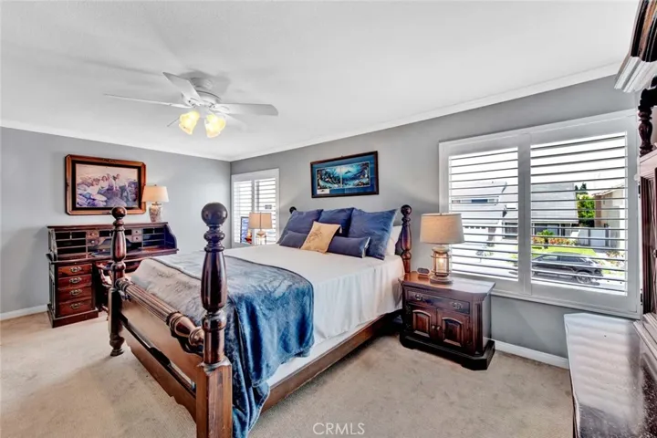 Primary Suite with Crown Molding, Ceiling Light Fan, Plantation Shutters, Milgard dual Pane Windows, 2 Walk-In Closets, and Spa-Style Remodeled Bathroom