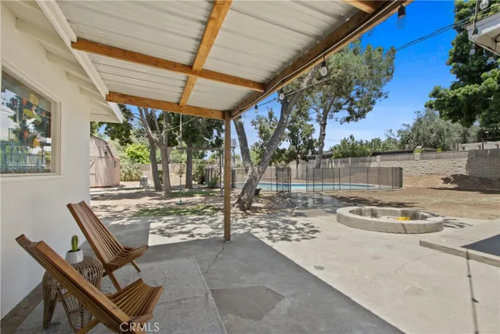 The private back yard has a covered porch, separate shed, gated pool and firepit.