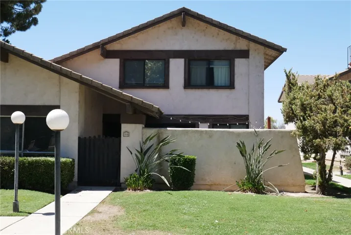 Exterior Front Elevation: 2-story unit, patio gate entry, tile roof, 2-pane windows, nicely landscaped common areas.