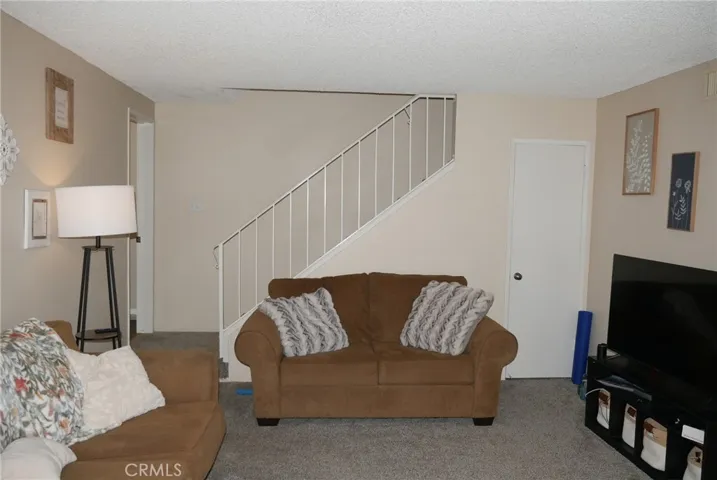 Living Room: large room, newer carpeting, coat closet, door to 1/2 bath opposite stairway.
