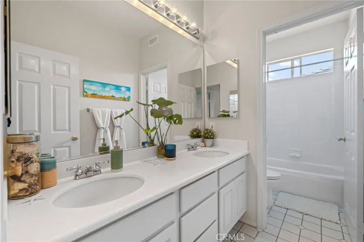 Upstairs bathroom has dual sinks and bath shower combination.