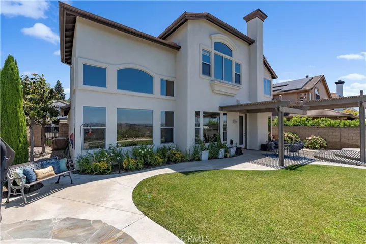 The backyard oasis features breathtaking views, spa, covered patio, outdoor BBQ, mature lemon, plum and magnolia trees.
