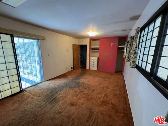 Primary bedroom with sliders out to pool deck and patio