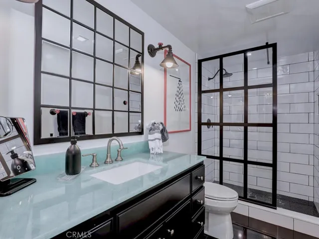 Downstairs full bath with glass vanity.