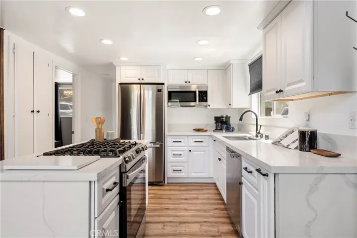 REMODELED KITCHEN WITH ISLAND, 5 BURNER STOVE, STAINLESS STEEL APPLIANCES.