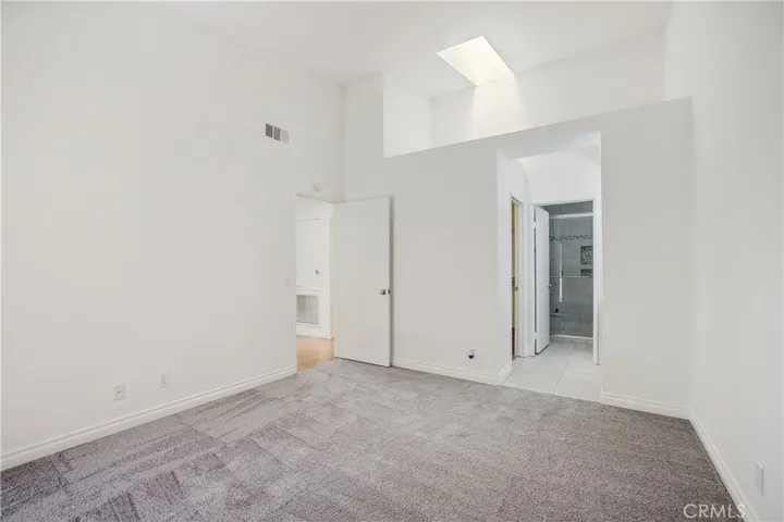 Master bedroom with vaulted ceiling and sky light