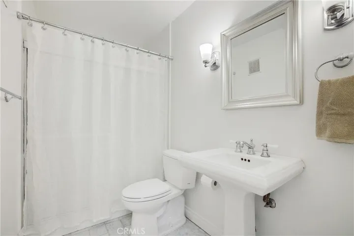 Guest bathroom with tile flooring and pedestal sink