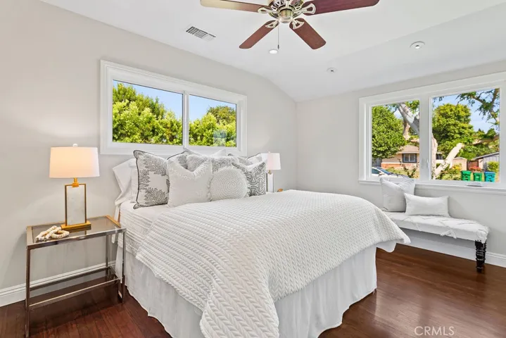 The large second bedroom features a charming coved ceiling and bright natural light through the windows