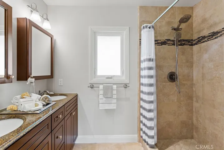 The renovated main bathroom features an oversized shower, double sink vanity, separate water closet and linen storage