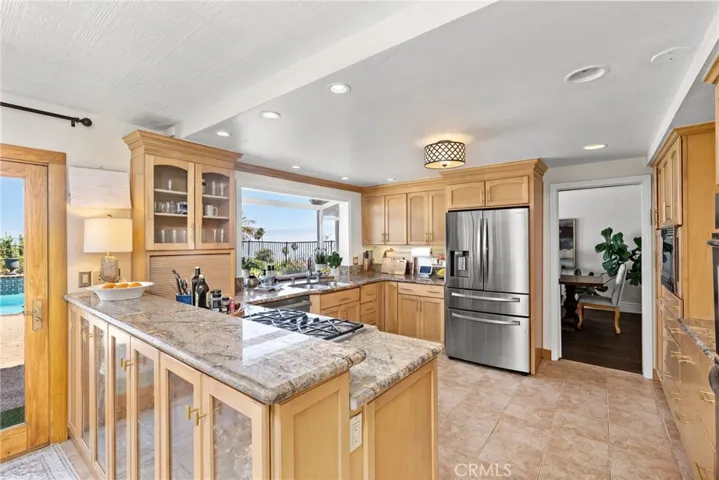 Bright eat-in kitchen, featuring stainless steel appliances and custom cabinets, flows seamlessly into the formal dining room and  family room.