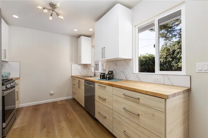 Wood-look lowers anchor the kitchen and bright white uppers lift and lighten