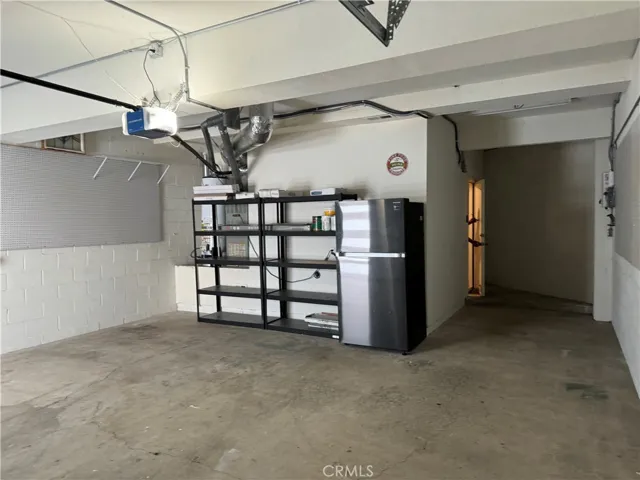 Shelving unit and refrigerator in garage.