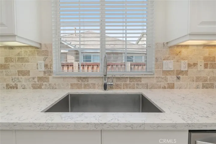 The stainless steel sink has a window above that provides a view of the backyard.