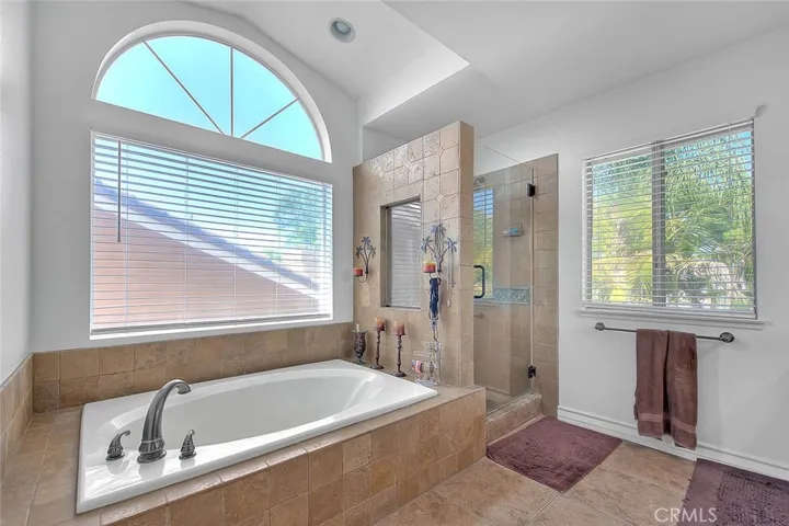 Soaking tub, tiled shower, frameless shower door.