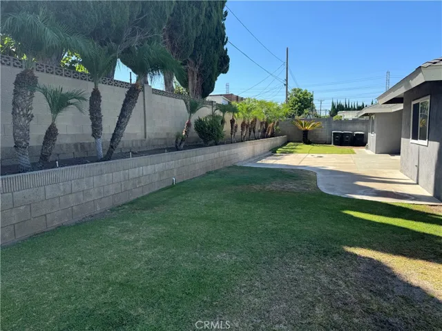 A low maintenance backyard with raised flowerbeds and block wall.