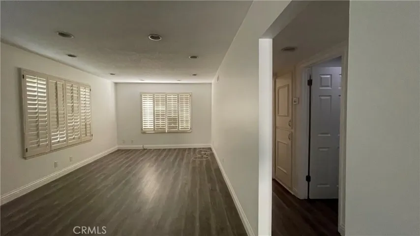 Spacious living room and hallway that leads to two bedrooms and bathrooms