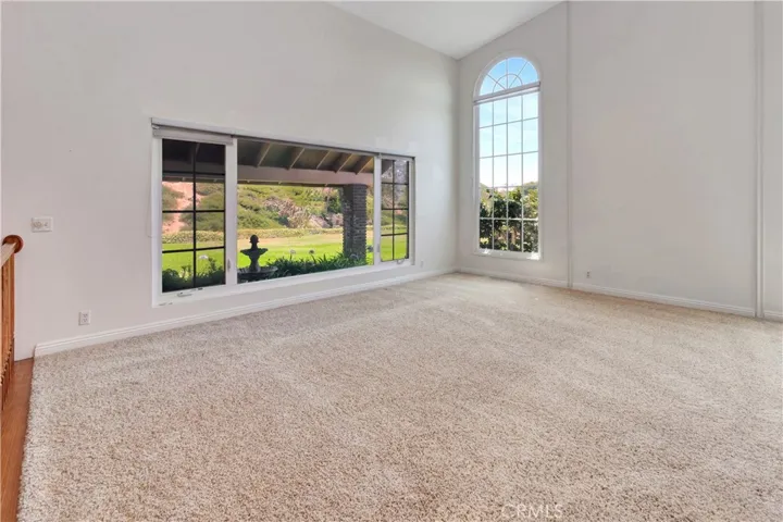 Living Room with High Ceiling and Decorative Windows Looking to South