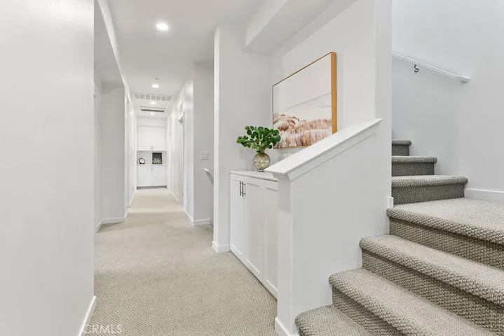 Wide 2nd floor hallway with three linen built-in cabinets; staircase leads to bonus loft on third floor