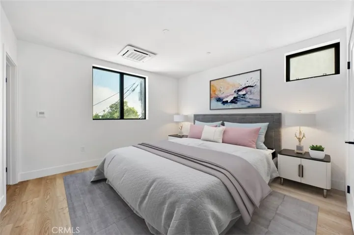 Primary bedroom has ocean view, en suite bathroom and walk in closet. Photo has been virtually staged
