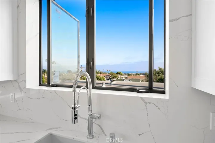 Ocean View from inside the living and kitchen area. Kitchen has stainless steel appliances and a center island.