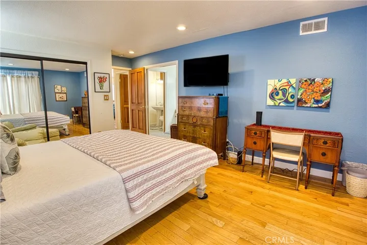 primary bedroom equipped with smart TV and work desk.