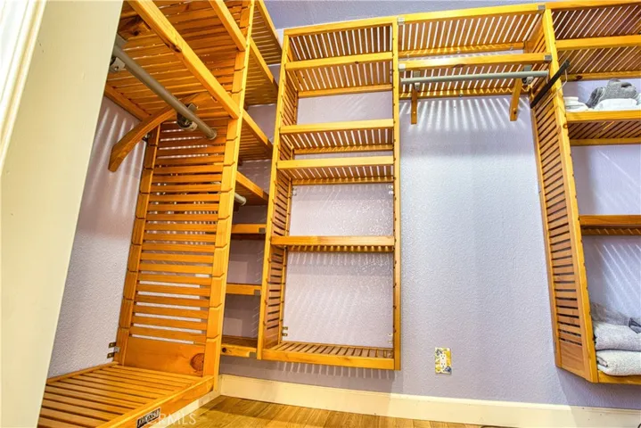 Master closet organizer enclosed with wardrobe mirrors.
