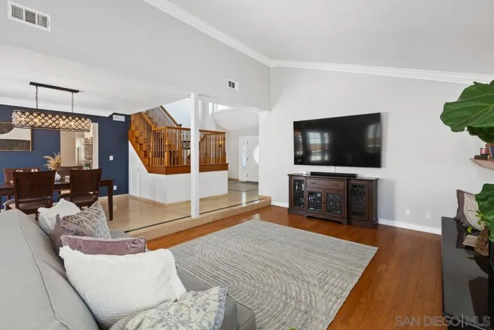 Extra large, open concept, living room with fireplace and expensive windows in French doors.