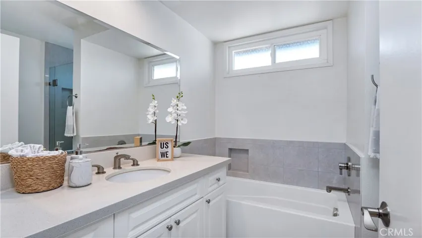 Primary bath with quartz counters and a sparkling tub.