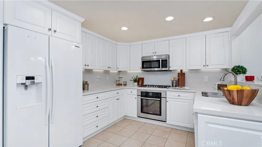 Remodeled kitchen has loads of cabinets, stainless sink, stove and microwave. New lighting and Quartz counters complete the picture. The refrigerator is included.