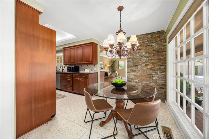 This kitchen boasts warm wood cabinets and stainless steel appliances. A vast expanse of glass windows offer maximum views of the outdoors.
