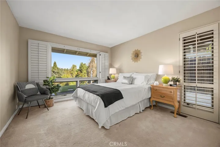 Bedroom #2 is bright and spacious with multiple windows with wood shutters. Sleep well and live better in this calm and restful space. Notice the private views as there are no neighbors behind this home.