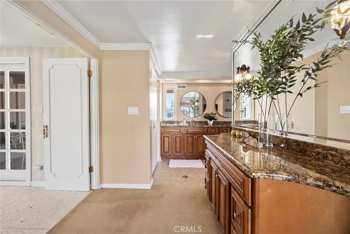 Spacious en suite primary bath include wood cabinets, dual sinks, granite countertops, a glass walk-in shower. In addition to the dual sink vanity, there is a separate dressing/vanity/makeup area.