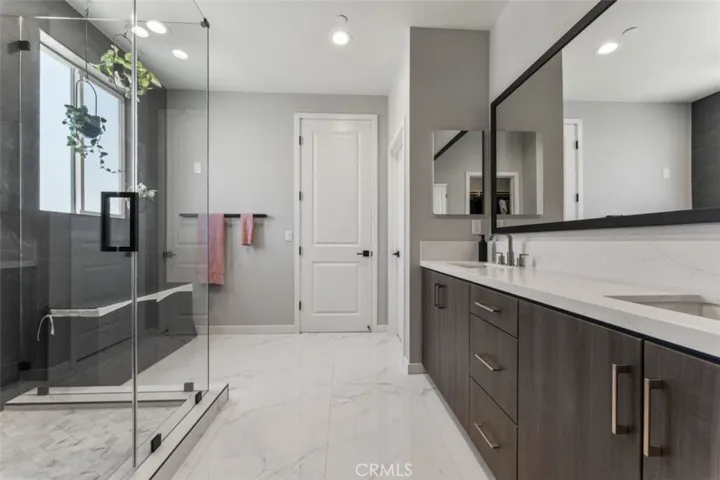 PRIMARY BATHROOM WITH FULLY UPGRADED OVERSIZED SHOWER, HIGH GLASS ENCLOSURE, BUILT-IN WALL NOOK, POWERED BIDET, DESIGNER SINK CABINET.