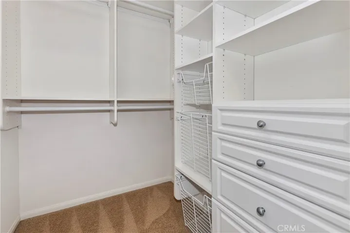 Walk in closet with organizers.