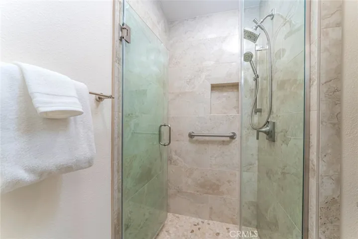 Travertine tiles step in shower with support bar