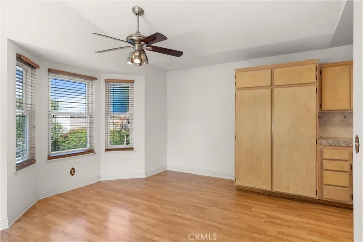 Dining area with ceiling fan and bay window